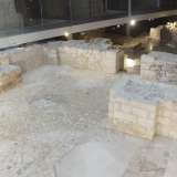 L�ambiente, in muratura chiara, � illuminato da piccoli faretti e percorso da un �sentiero� a vetrate che mostra sotto i piedi la base del bastione. 
